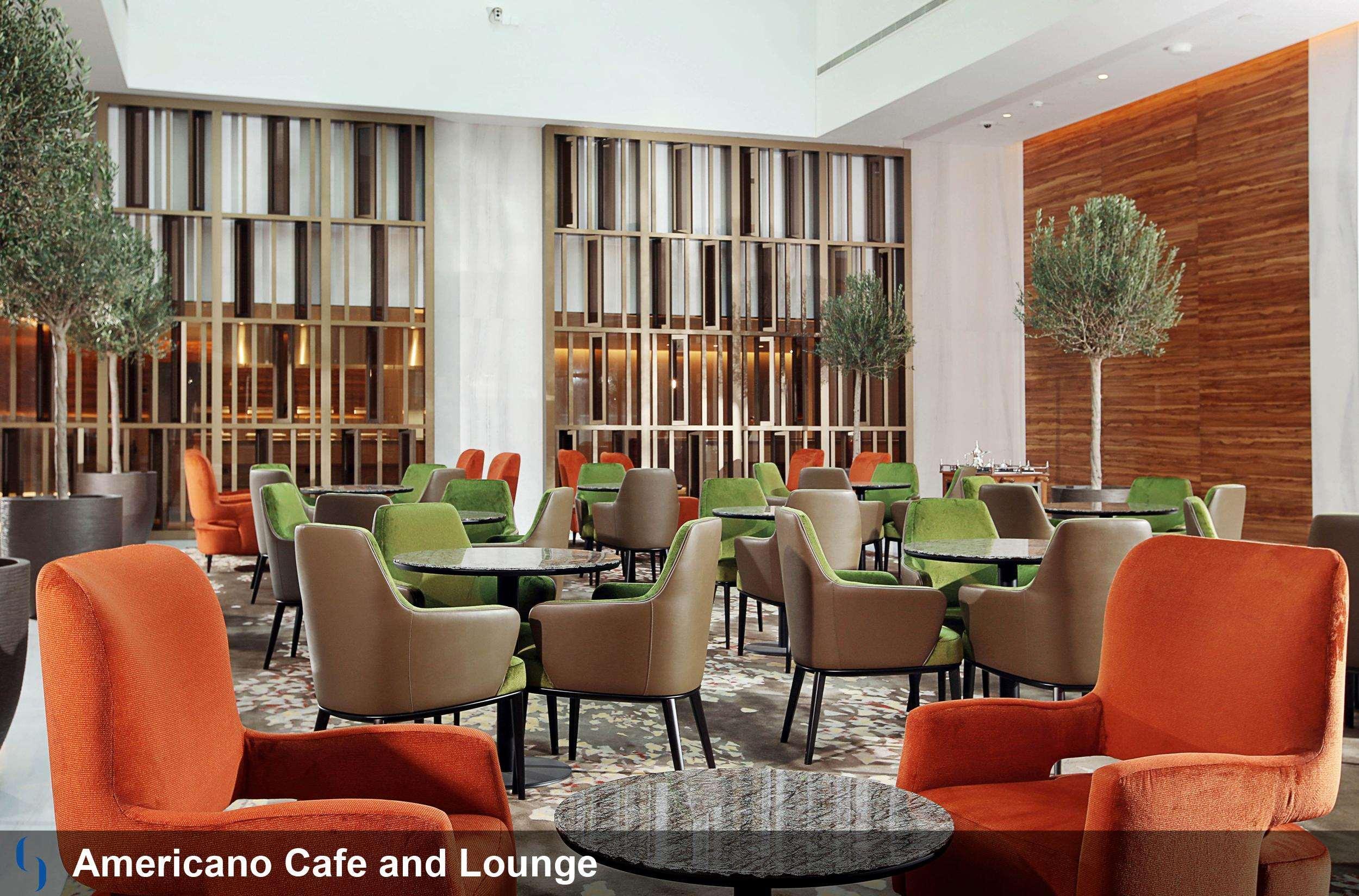 迪拜大都会大酒店 外观 照片 The image shows a modern café and lounge area called "Americano Café and Lounge." The interior features a spacious, well-lit design with a mix of stylish furniture. There are several seating areas with comfortable chairs in various colors, including 