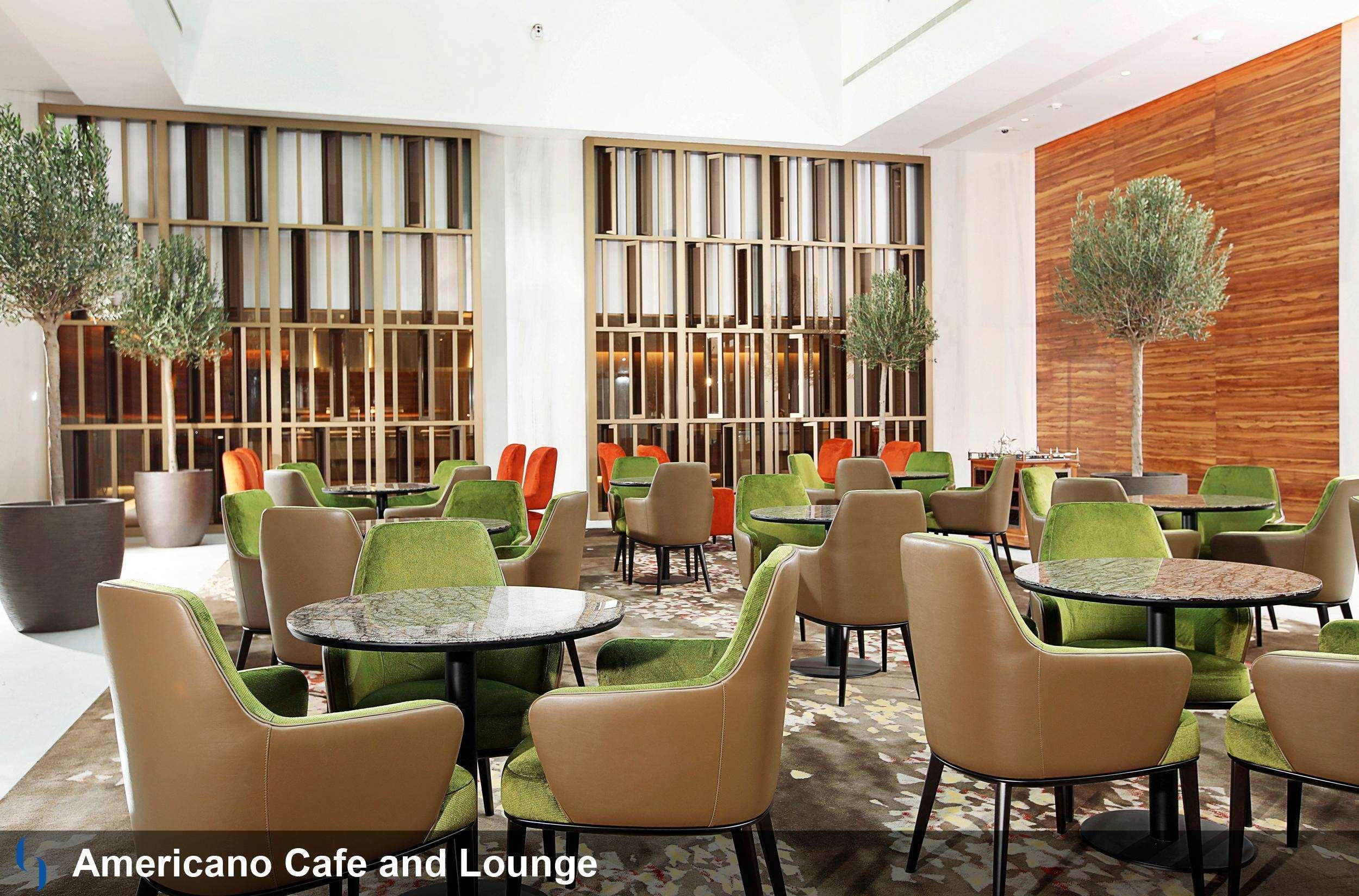迪拜大都会大酒店 外观 照片 The photo showcases a modern cafe and lounge called "Americano Cafe and Lounge." The interior features a spacious area with various seating arrangements. There are several round tables surrounded by green and beige chairs, creating a fresh and inviti