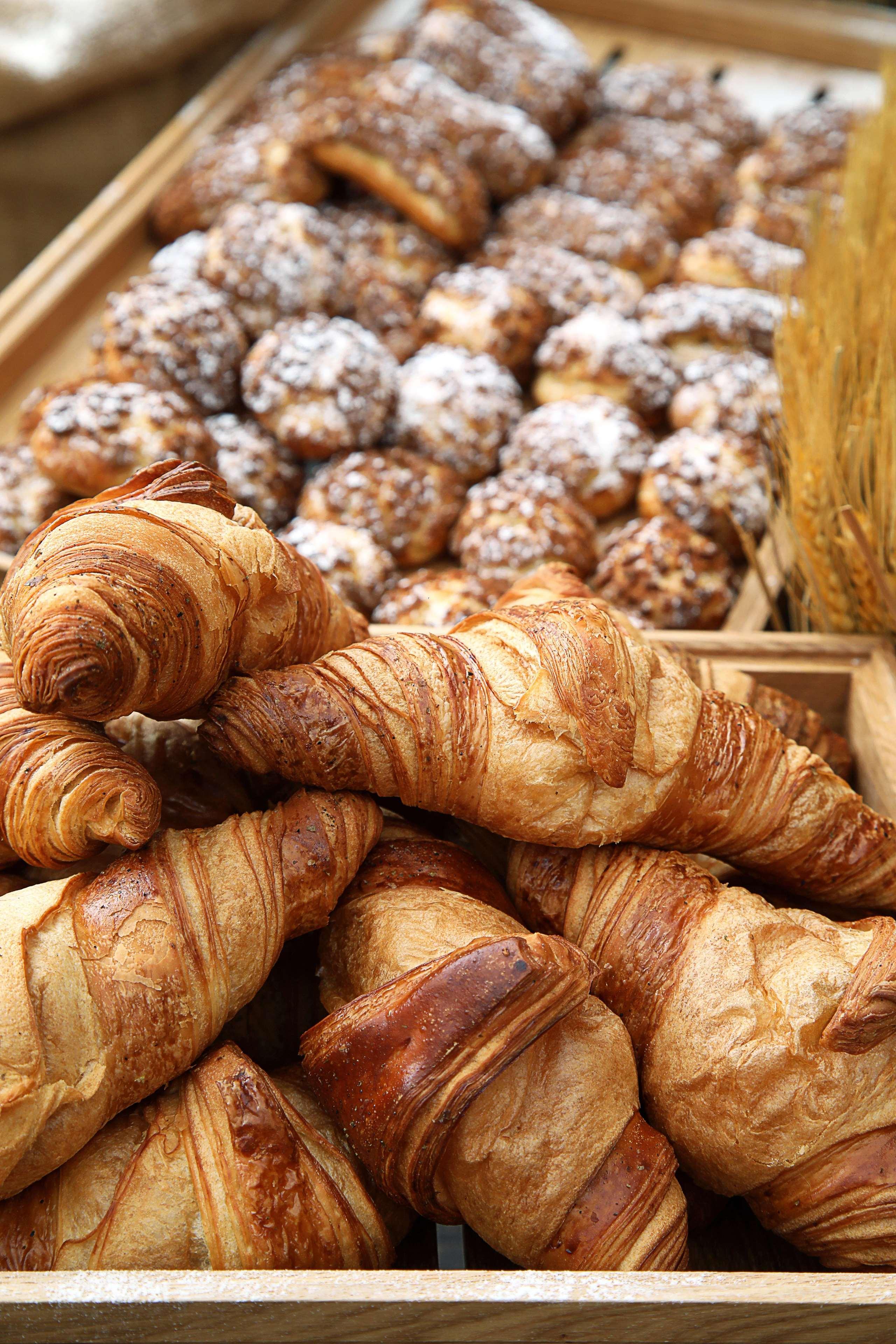 迪拜大都会大酒店 外观 照片 The photo displays a selection of baked goods, prominently featuring several golden-brown croissants. The croissants are flaky and have a distinct, spiral shape characteristic of this pastry. In the background, there are additional baked items, possi