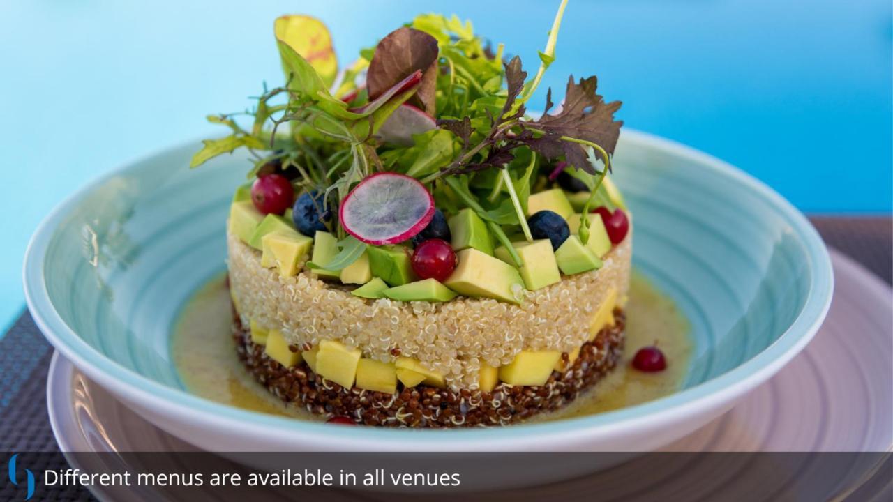 迪拜大都会大酒店 外观 照片 The photo features a beautifully arranged dish that resembles a layered salad or a savory cake. It consists of various fresh ingredients, including avocado, diced mango, blueberries, and radishes, all artfully layered to create an appealing presentat
